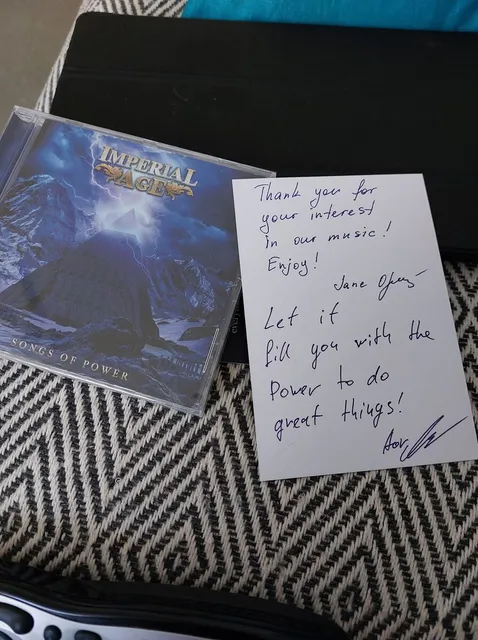 Songs of Power CD with a handwritten note from the band